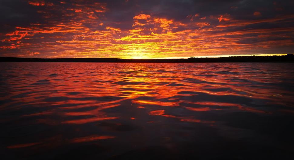 Free Image of The Sun Setting Over a Body of Water 