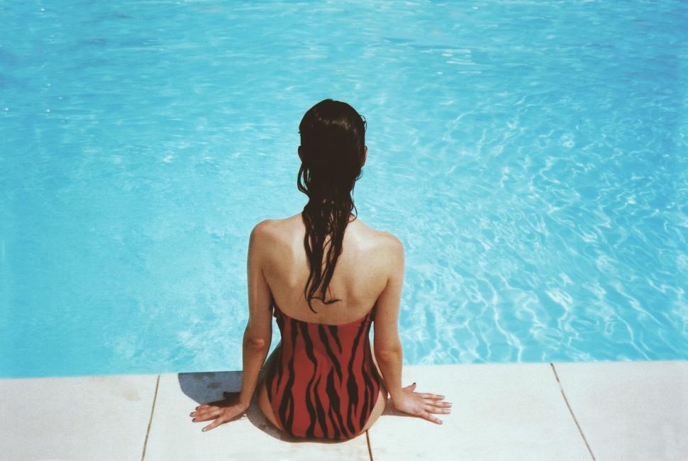 Free Image of Woman Sitting by Swimming Pool 