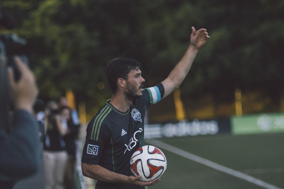 Free Image of Man Holding Soccer Ball on Field 