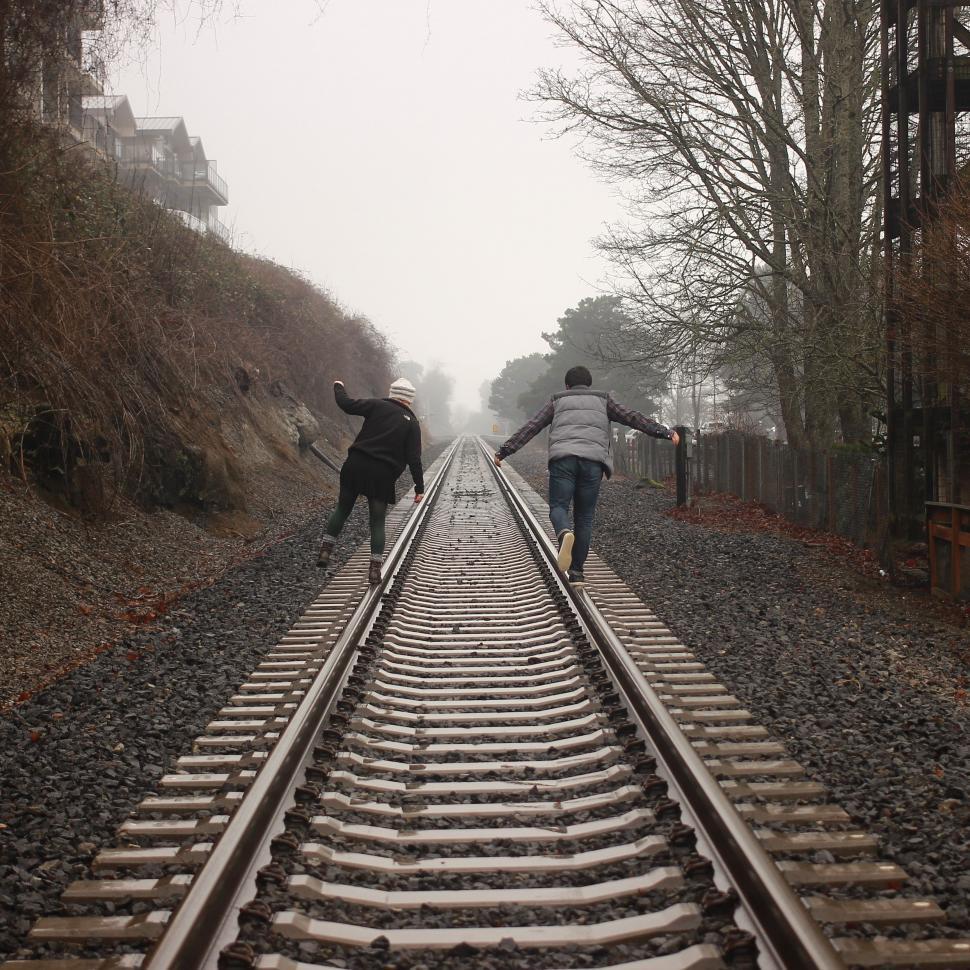 Free Image of Couple Walking Down Train Track 