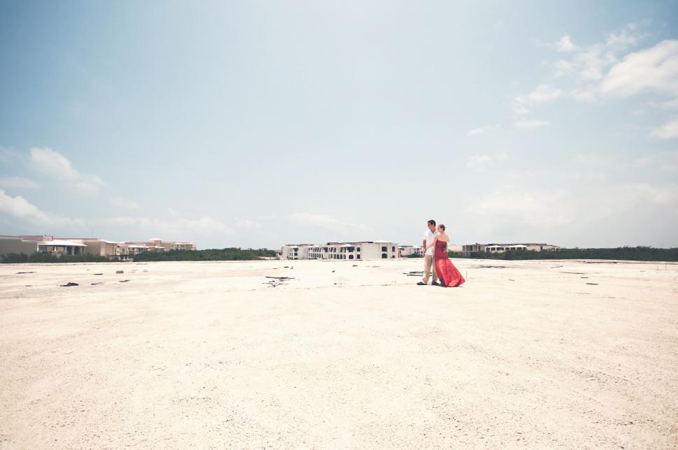 Free Image of Woman in Red Dress Standing on Beach 