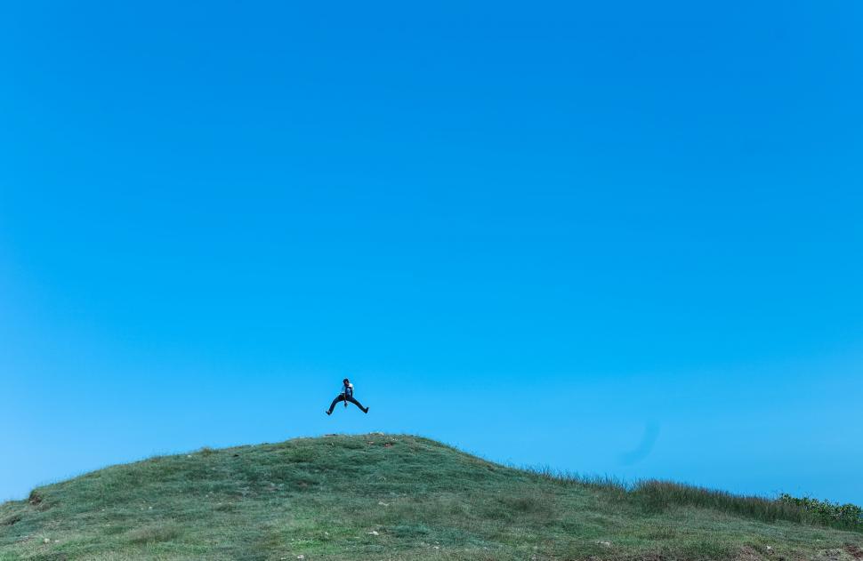 Free Image of Person Standing on Top of Grass Covered Hill 
