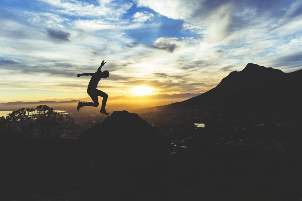 Free Image of Person Jumping in the Air on Top of a Mountain 