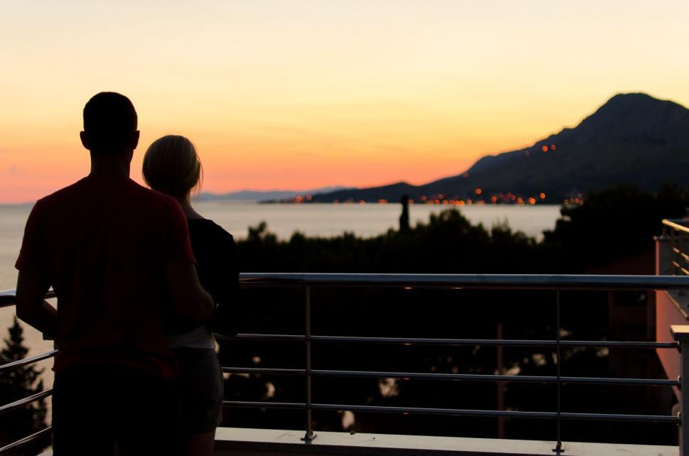 Free Image of Couple Standing on Balcony Overlooking Cityscape 