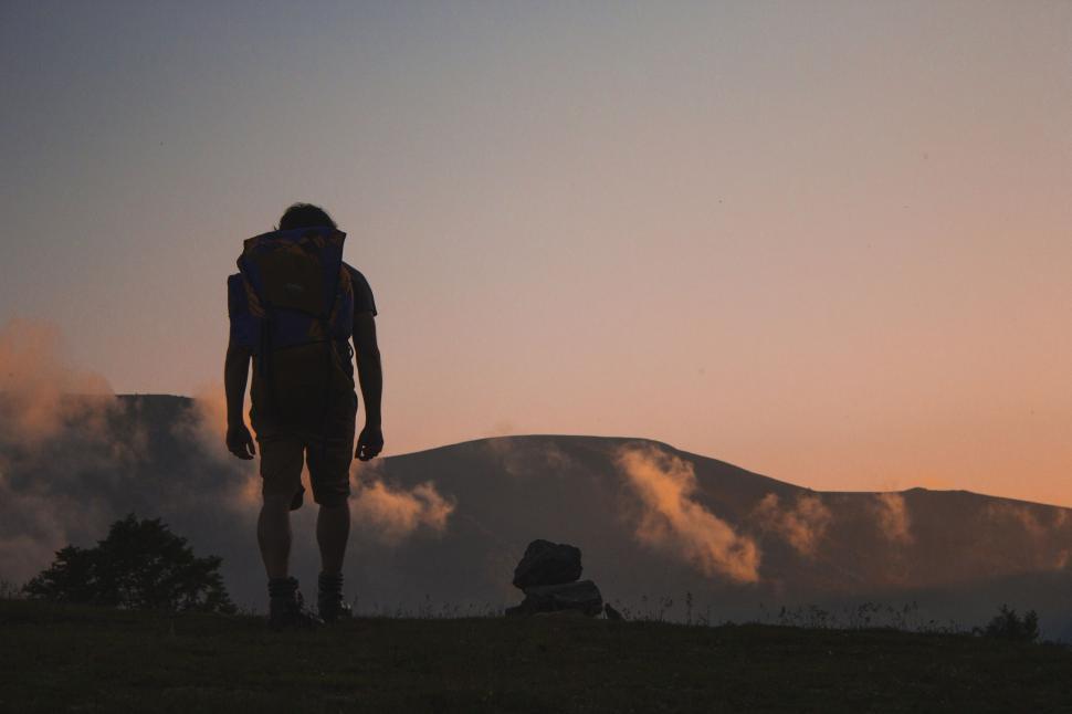 Free Image of Man Standing on Top of a Hill With Backpack 