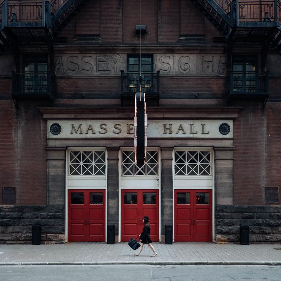 Free Image of Person Walking in Front of Building With Two Red Doors 