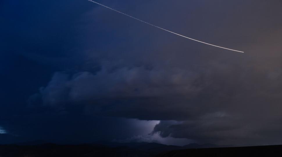 Free Image of Plane Flying Through Cloudy Night Sky 