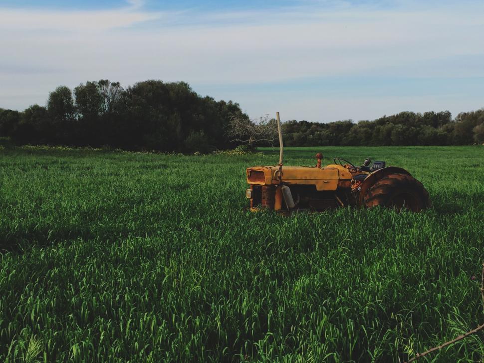 Free Image of A Tractor Working in a Green Grass Field 