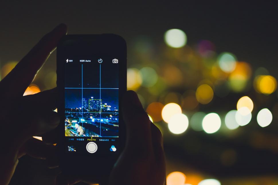 Free Image of Person Taking Picture of City at Night 