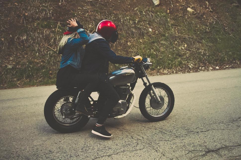 Free Image of Man and Woman Riding Motorcycle Down Street 
