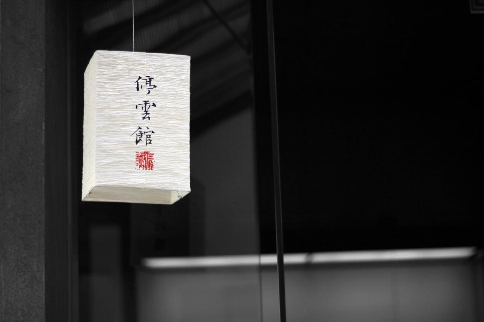 Free Image of Paper Lantern Hanging From Wire in Front of Window 