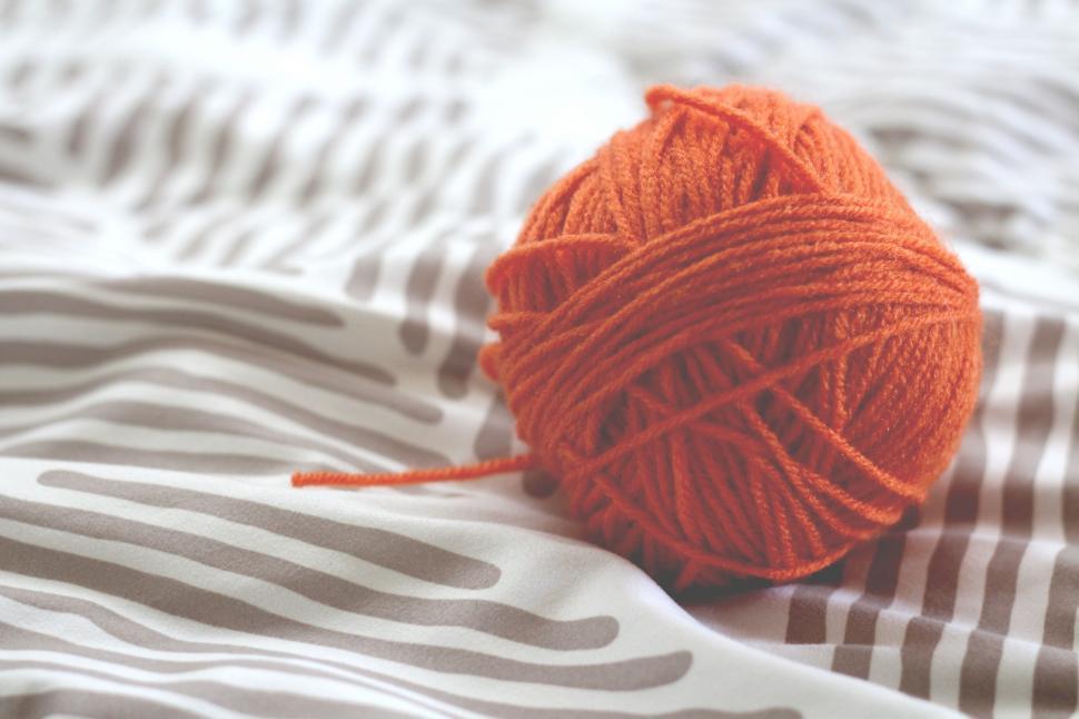 Free Image of Ball of Yarn on Bed 