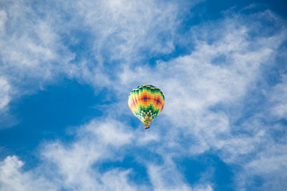 Free Image of Hot Air Balloon Flying Through Cloudy Blue Sky 