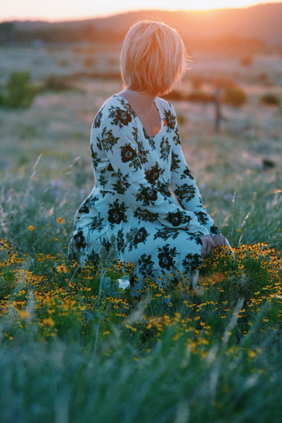 Free Image of Woman Sitting in Field at Sunset 