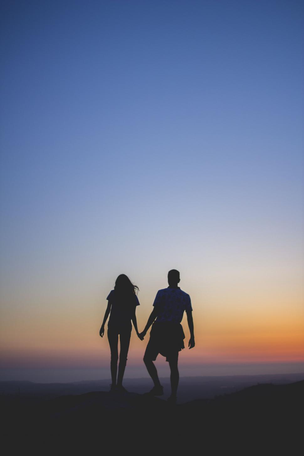 Free Image of A Man and a Woman Holding Hands at Sunset 