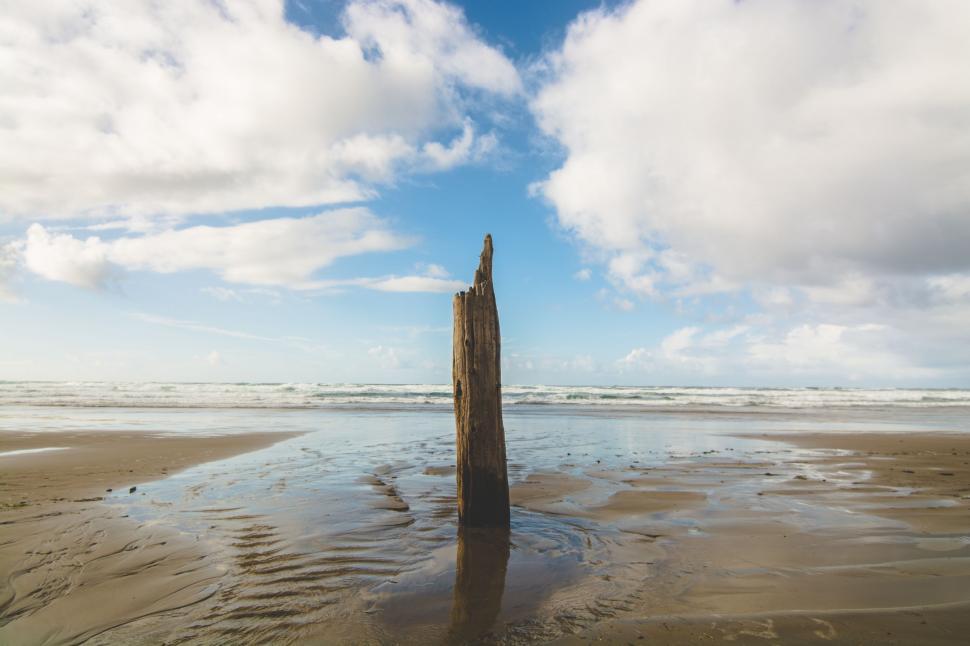 Free Image of Large Wooden Plank Sticking Out of Sand 