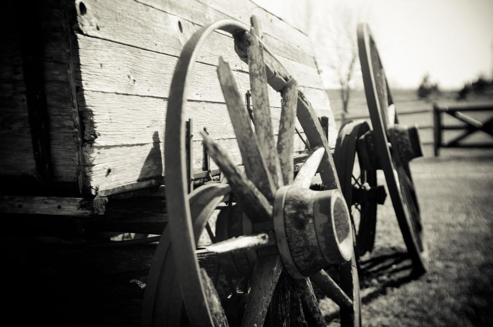 Free Image of Leaning Wagon Wheel Against Wooden Wall 