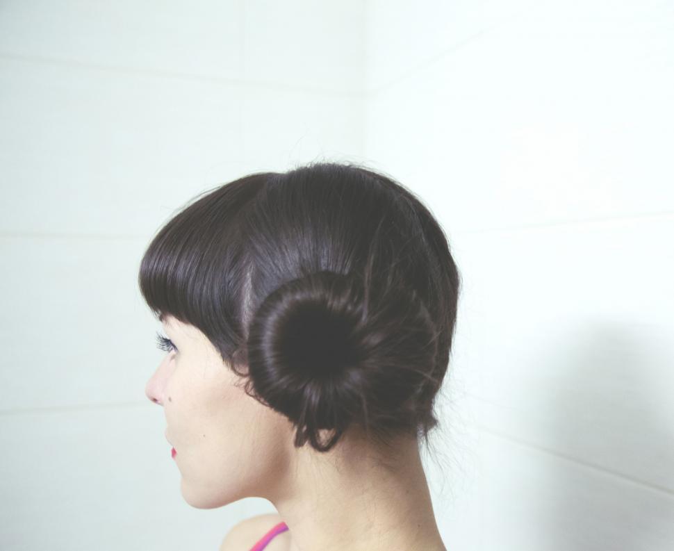 Free Image of Woman Styling Hair Into Bun 