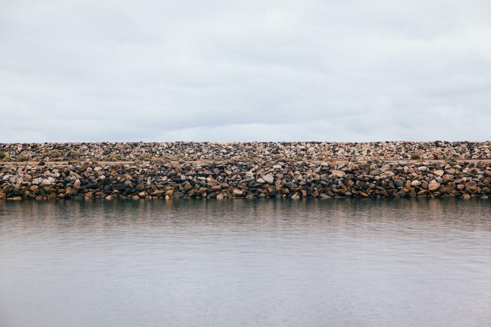Free Image of Large Body of Water Next to Stone Wall 