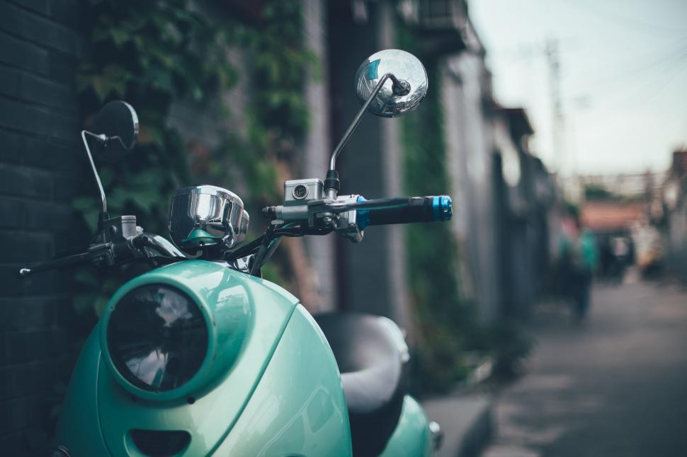 Free Image of Green Scooter Parked on Side of Street 