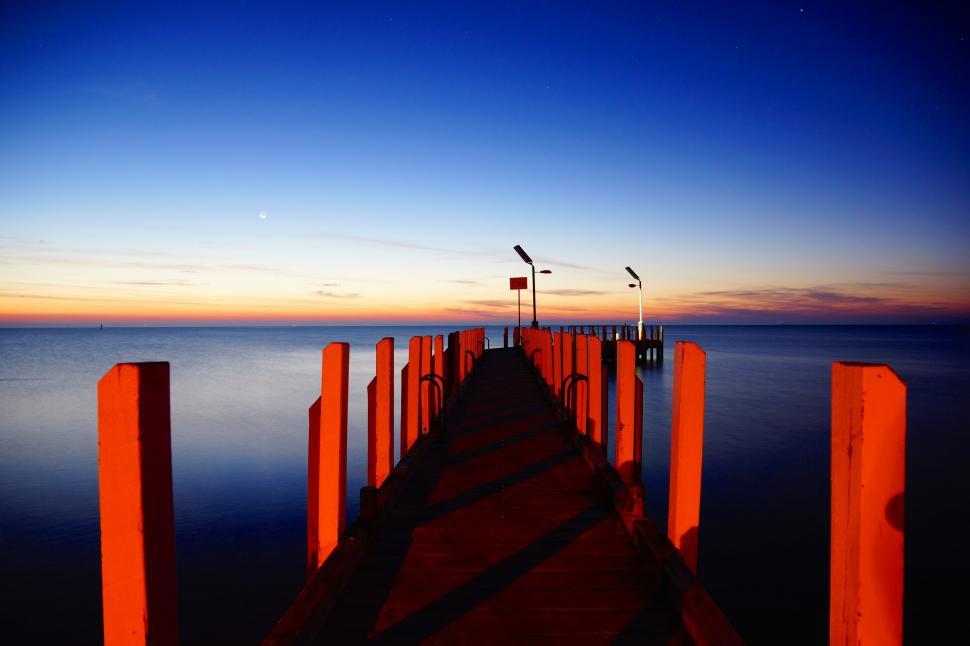 Free Image of Long Pier Extending Into Body of Water 