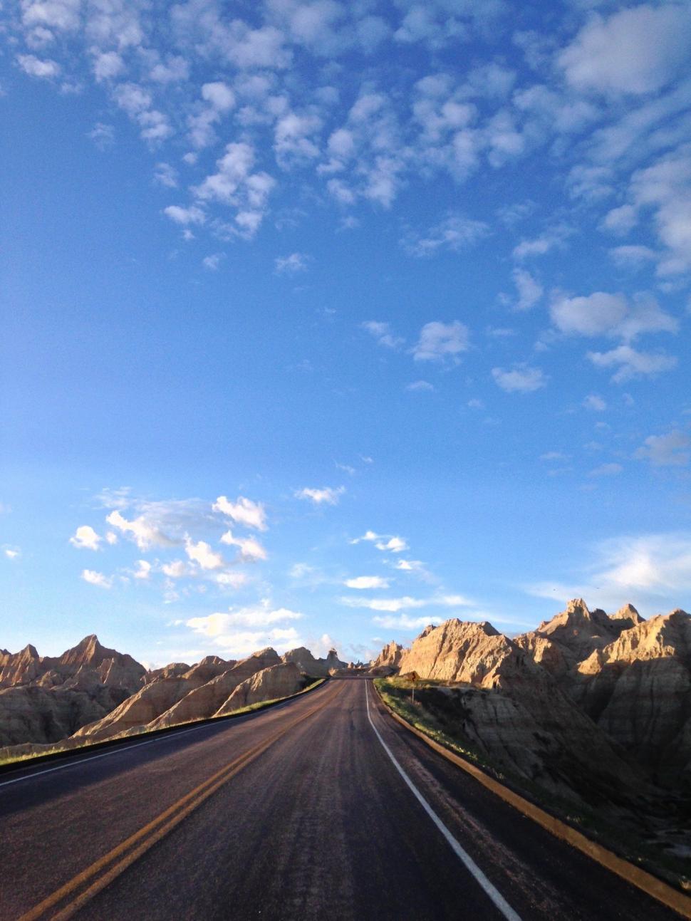 Free Image of Driving Down a Road With Mountains in the Background 