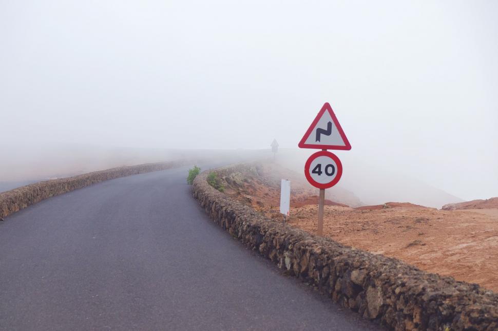 Free Image of Foggy Road With Two Red and White Signs 