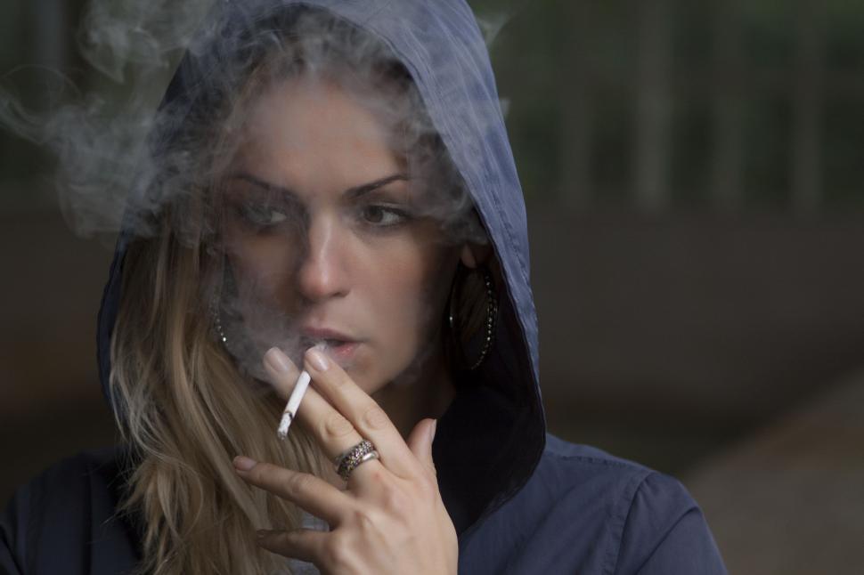 Free Image of Woman Smoking Cigarette in Hoodie 