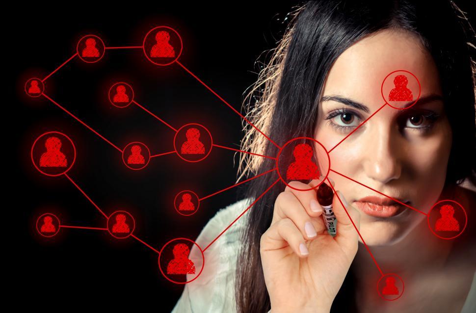 Download Free Stock Photo of Woman sketching a social network on virtual screen 