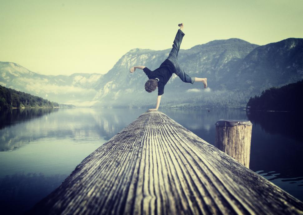 Free Image of Young boy handstanding on jetty 