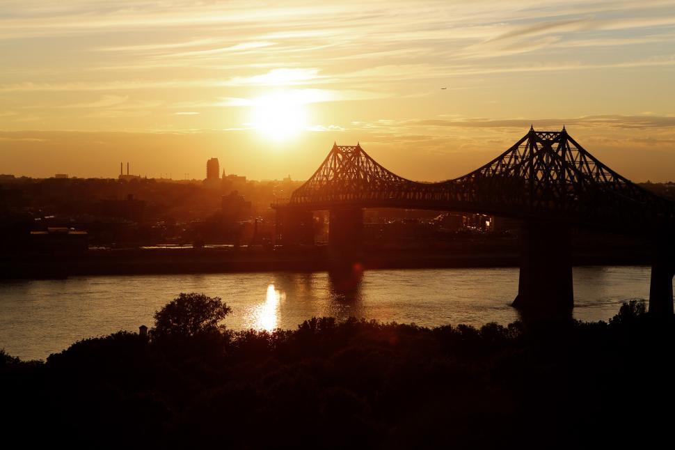 Free Image of Sun Setting Over Bridge on River 