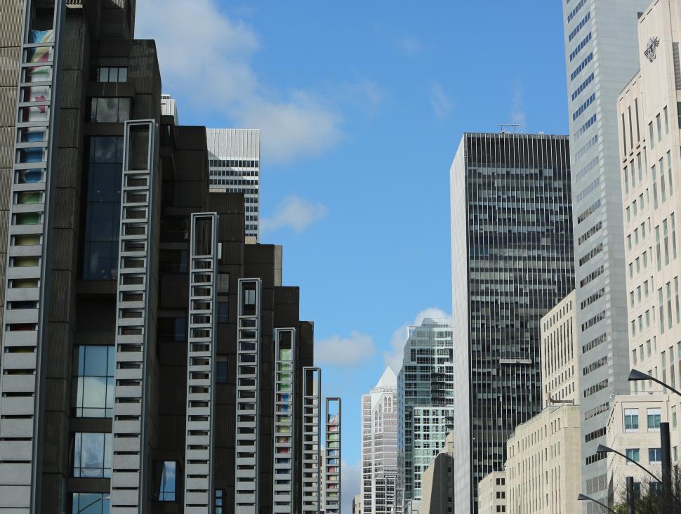 Free Image of City Street Filled With Tall Buildings Under a Blue Sky 