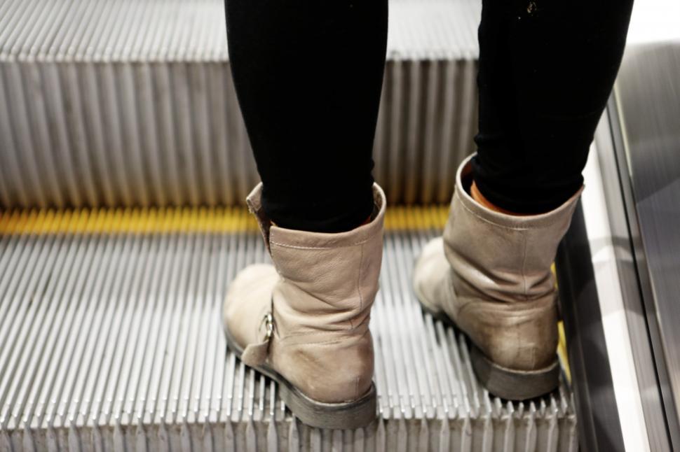 Free Image of Person Standing on Escalator With Feet Up 