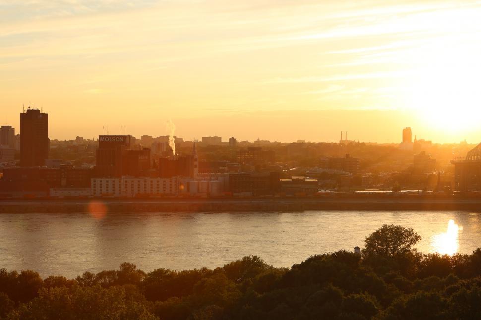 Free Image of Sun Setting Over City and Body of Water 