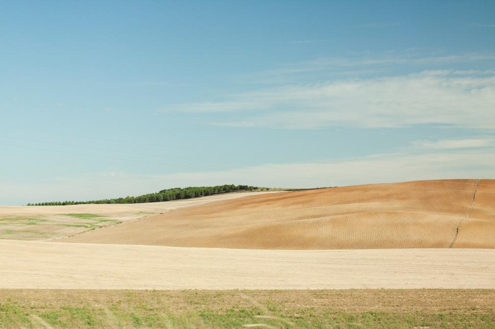 Free Image of Rolling Hill Overlooking Large Field of Grass 