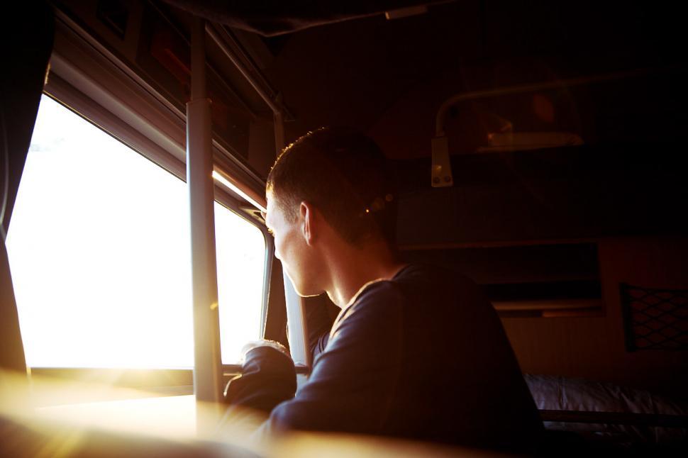 Free Image of Man Sitting in Train Looking Out the Window 