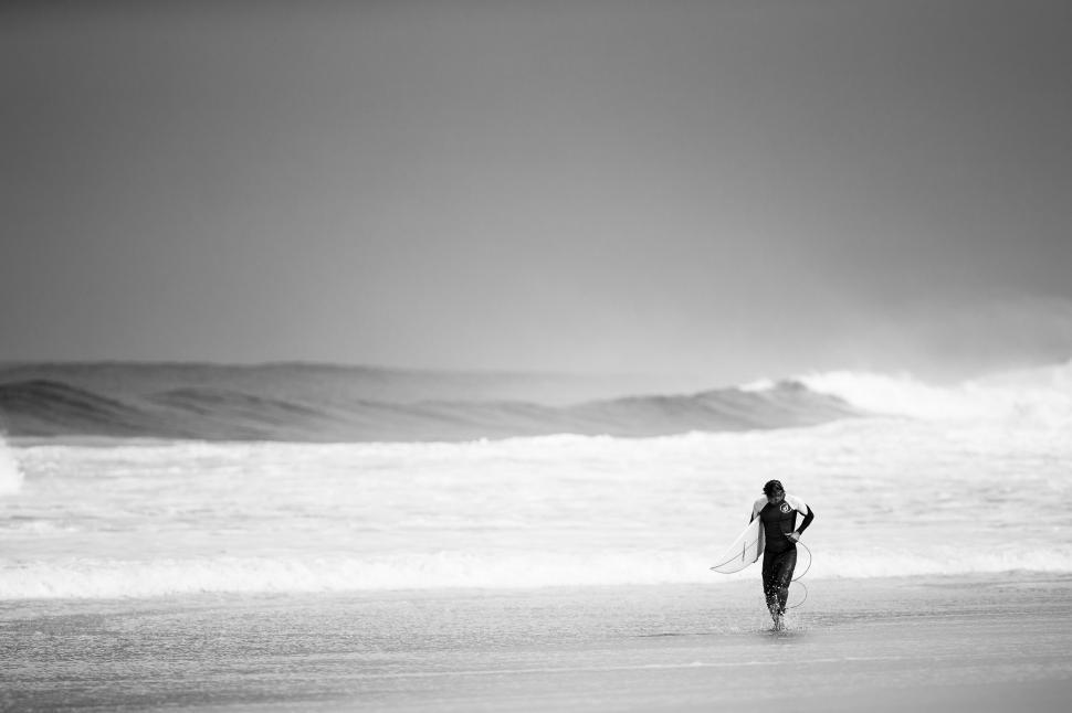Free Image of Person Walking on Beach With Surfboard 