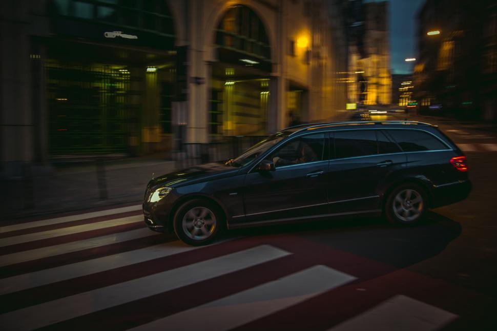 Free Image of Black Car Driving Down Street at Night 