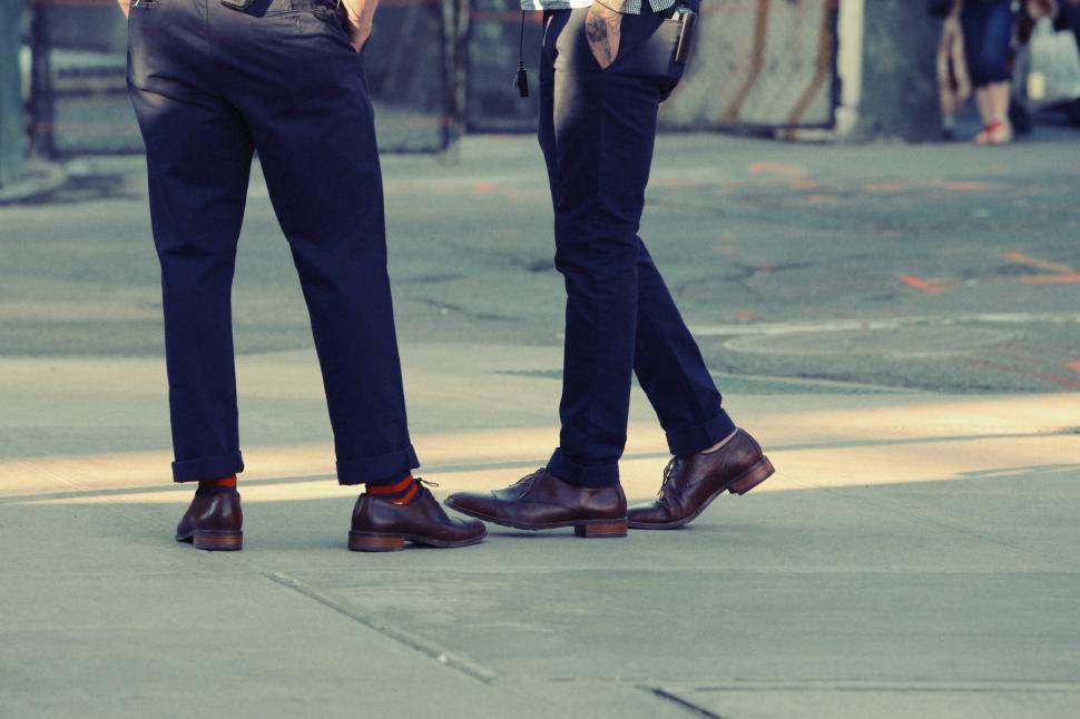 Free Image of Two Men Standing Together on a Sidewalk 