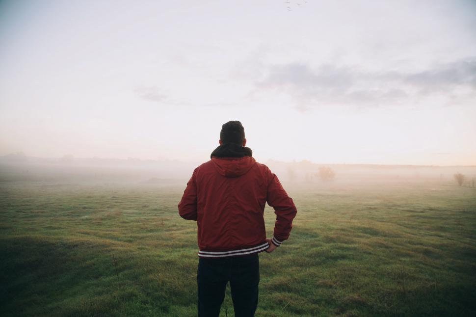 Free Image of Man in Red Jacket Standing in Field 