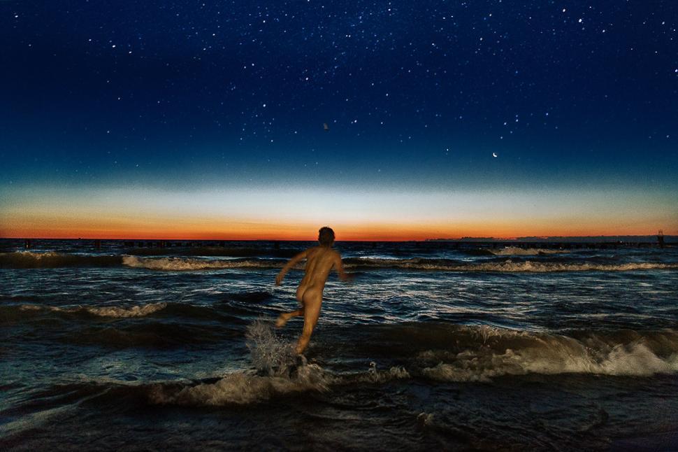 Free Image of Man Standing on Beach Under Night Sky 