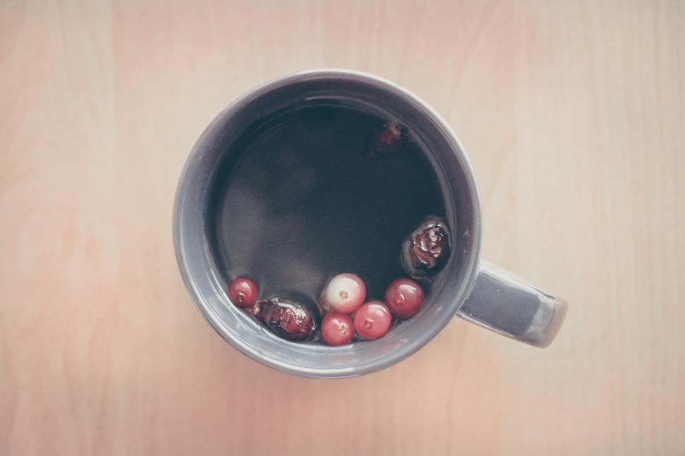 Free Image of Cup Filled With Red and White Balls on Wooden Table 