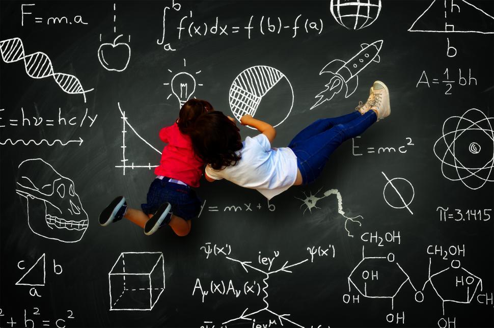 Download Free Stock Photo of Two little girls writing on a blackboard with science subjects 