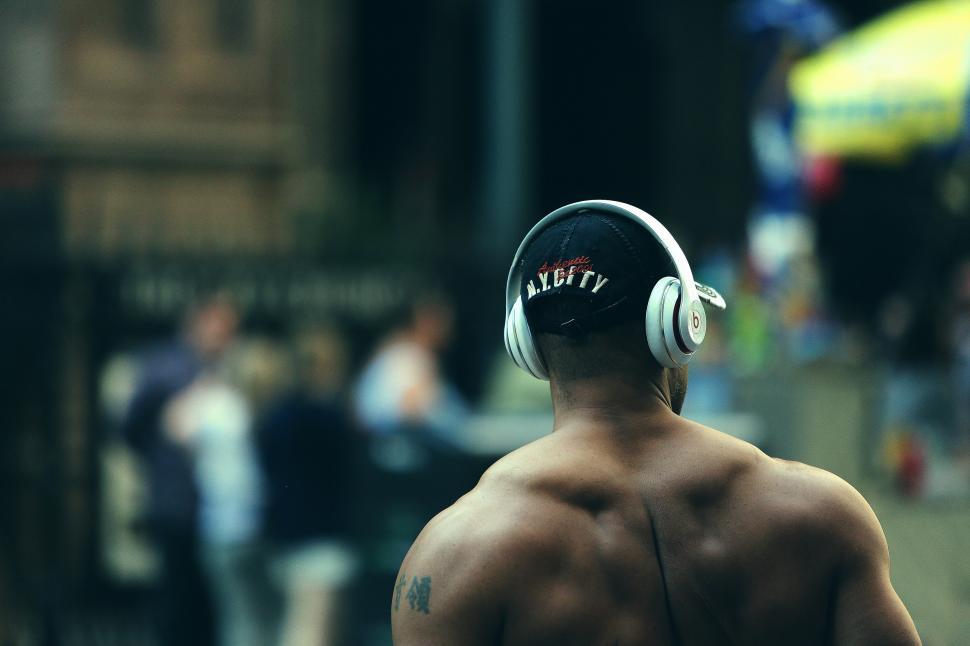 Free Image of Man Walking Down Street With Headphones On 