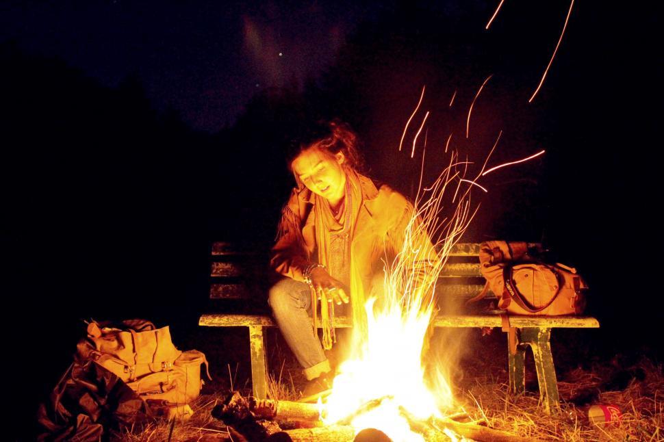 Free Image of Man Sitting on Bench Next to Fire 