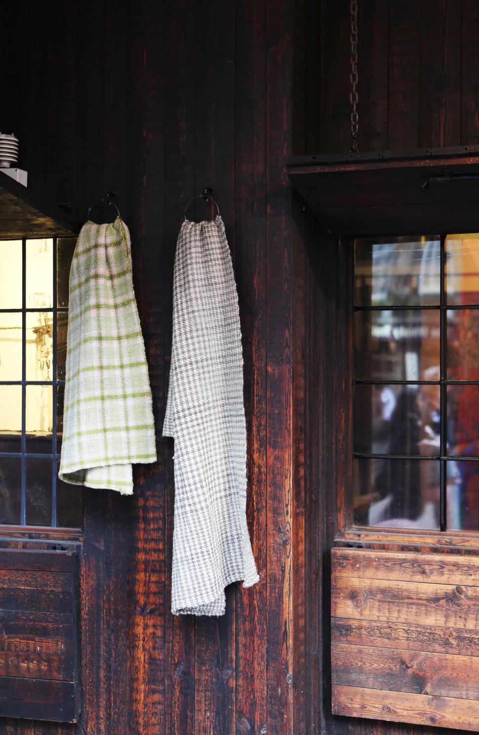 Free Image of Two Towels Hanging on Wooden Wall Next to Window 