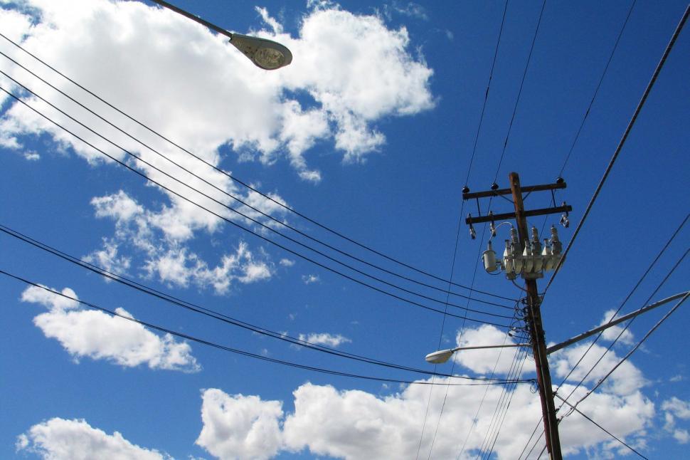 Free Image of power line telephone pole infrastructure ugly city street light streetlight clouds blue sky transformer 