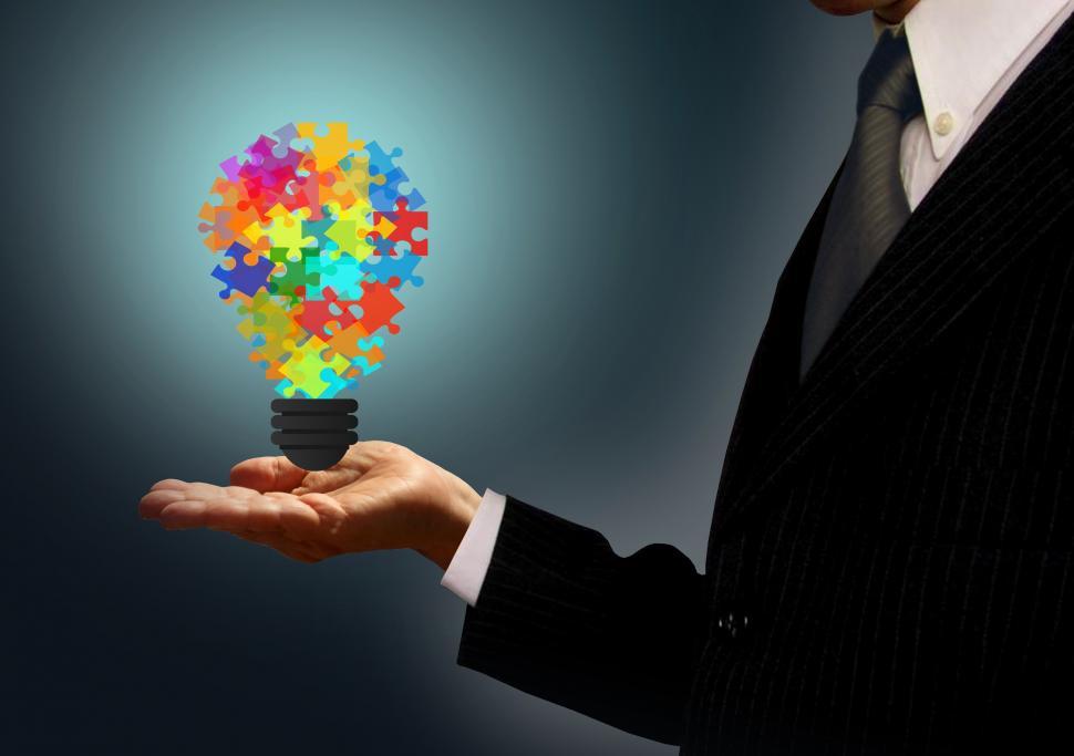 Download Free Stock Photo of Businessman holding a jigsaw lightbulb - Ideas and creativity co 