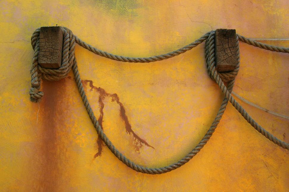 Free Image of Yellow Wall With Hanging Ropes 