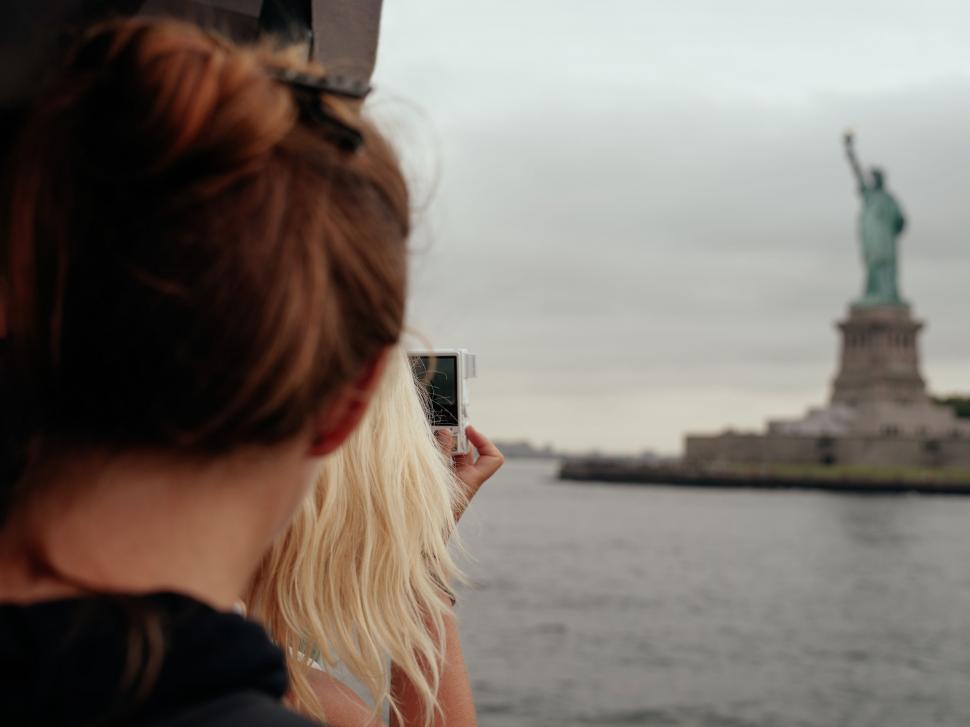 Free Image of Woman Taking Picture of Statue of Liberty 